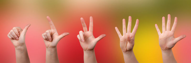 Close-up of hand against colored background