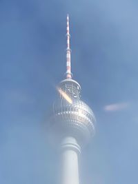 Low angle view of communications tower against sky in city