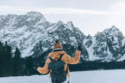 Rear view of woman skiing on snowcapped mountain