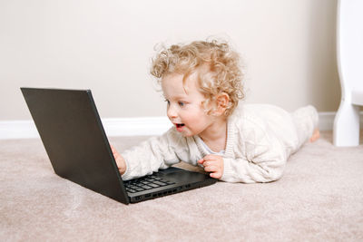 Toddler baby boy working on laptop. little kid child using technology. early age education 