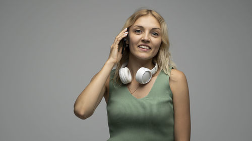 Portrait of young woman standing against wall