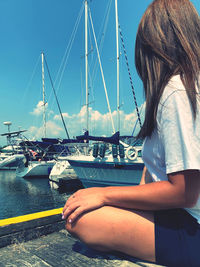 Woman looking at harbor against sky