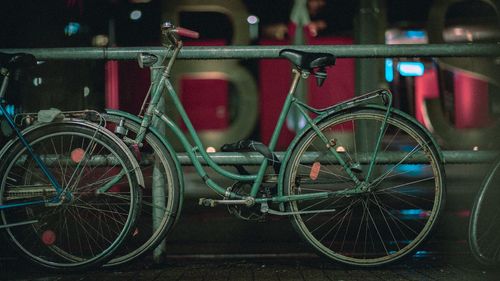 Close-up of bicycle standing by railing