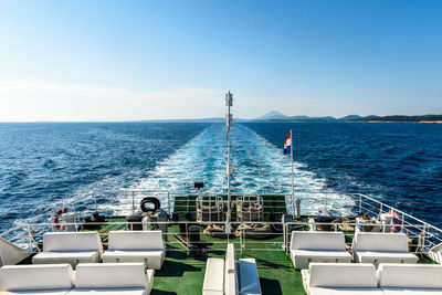 Boats sailing in sea against clear blue sky