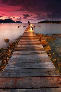 Long jetty at the beach with sunset background