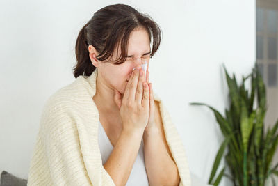 Woman in bed with the flu, sneezing  sick blowing nose