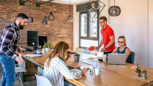 Businessmen having fun playing with a basket ball in coworking office