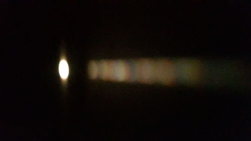Close-up of illuminated lights against sky at night