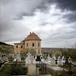 View of cemetery and buildings against sky