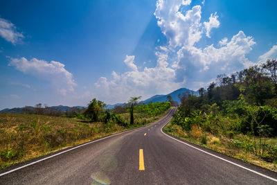 Road leading towards mountains against sky