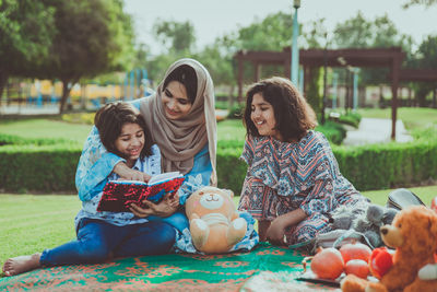 Mother with cheerful daughters enjoying at park