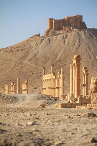 Old architectural columns in desert against mountain