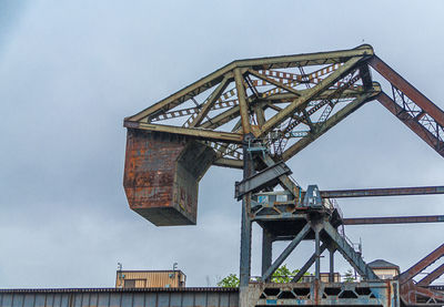 Low angle view of crane against sky