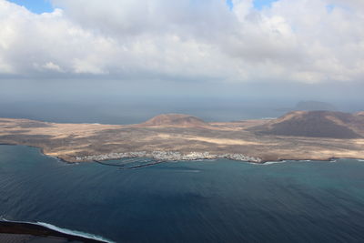 Scenic view of sea and mountains against sky