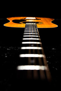 Close-up of guitar against black background