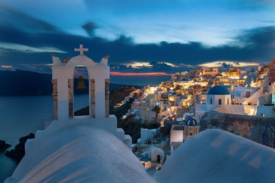 Buildings by sea against sky during winter