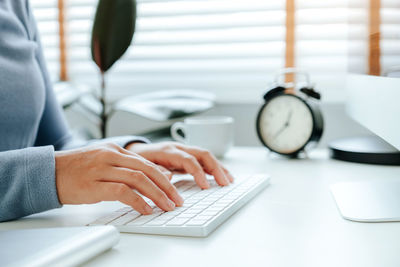 Midsection of woman using laptop on table