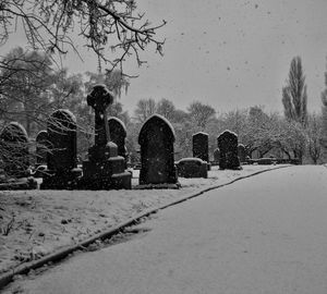 Snow covered cemetery against clear sky