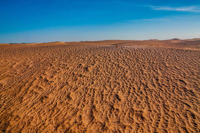 Scenic view of desert against clear blue sky