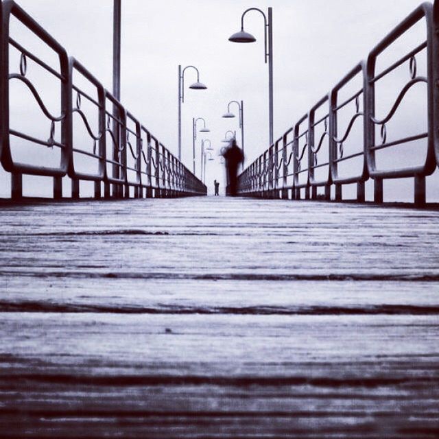 the way forward, railing, built structure, surface level, architecture, pier, clear sky, rear view, walking, wood - material, boardwalk, full length, footbridge, diminishing perspective, sky, men, selective focus, day