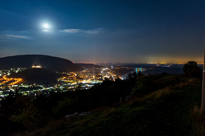 Illuminated cityscape against sky at night