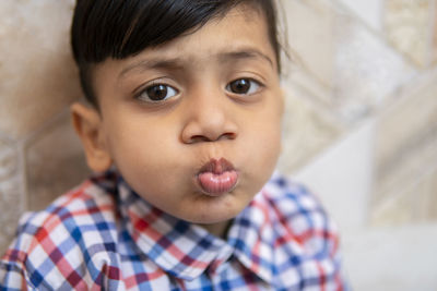 Close-up portrait of cute boy puckering while sitting on steps