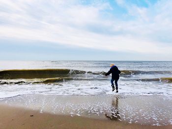 Full length of woman on beach against sky