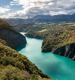 High angle view of lake and mountains against sky