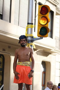 Full length of shirtless man standing in city