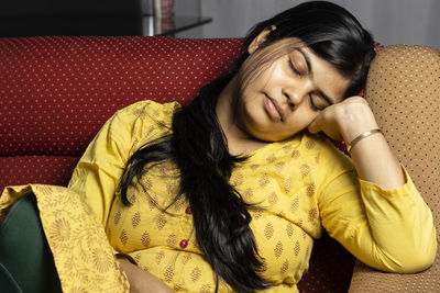 Young woman sitting on sofa at home