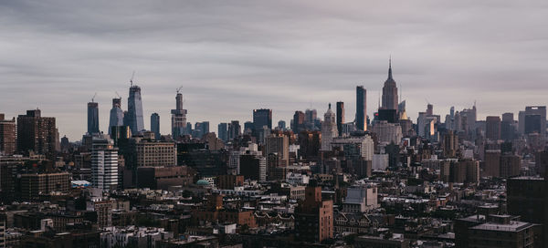 View of buildings in city against cloudy sky