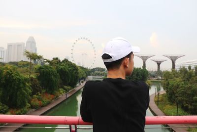 Rear view of man leaning on railing of dragonfly bridge at gardens by the bay