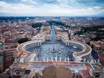 High angle view of st peters square and cityscape against cloudy sky