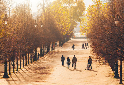 Group of people walking on footpath during autumn