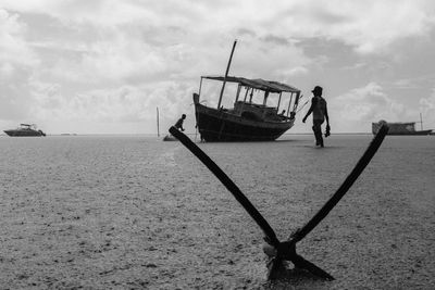 Man walking by fishing boat at riverbank