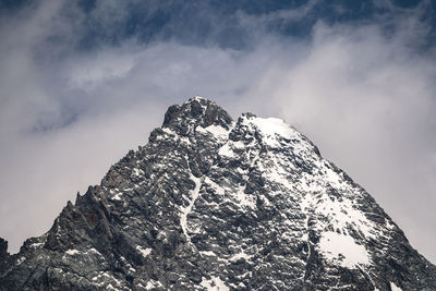 Low angle view of snowcapped mountain against sky