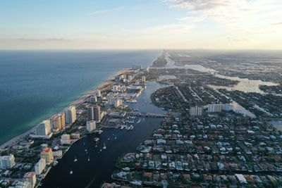 High angle view of buildings by sea against sky