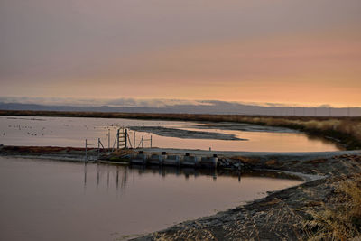 Scenic view of lake against sky during sunset