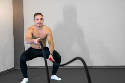 Portrait of young woman exercising in gym