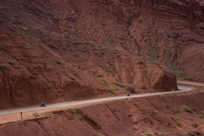 People riding motorcycles on road by mountain