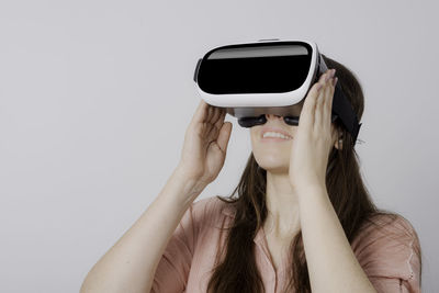 Close-up of woman with virtual reality simulator against wall