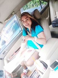 Portrait of smiling girl sitting in car