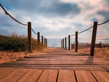 Wooden pier on sea against sky