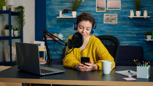 Smiling woman streaming while sitting at home