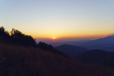 Scenic view of silhouette mountains against sky at sunset