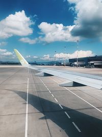 Airplane on airport runway against sky