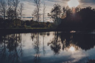 Reflection of trees in lake against sky during sunset