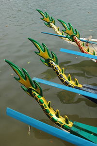 Artificial dragon tails on boats moored in river