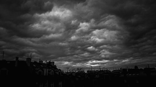 Buildings in city against cloudy sky