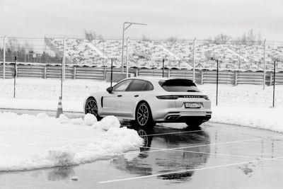 Car on snow covered road against sky